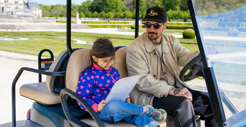 Un père et sa fille dans une voiturette électrique à Vaux-le-Vicomte